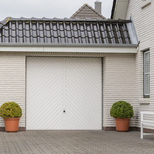 Garage mit Einfahrt und weißem Tor direkt am Haus